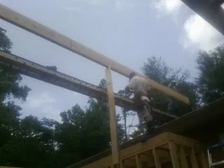Carpenter setting a ridge beam over a new addition frame — Ice Dam Removal by Roofing Brothers in York Springs