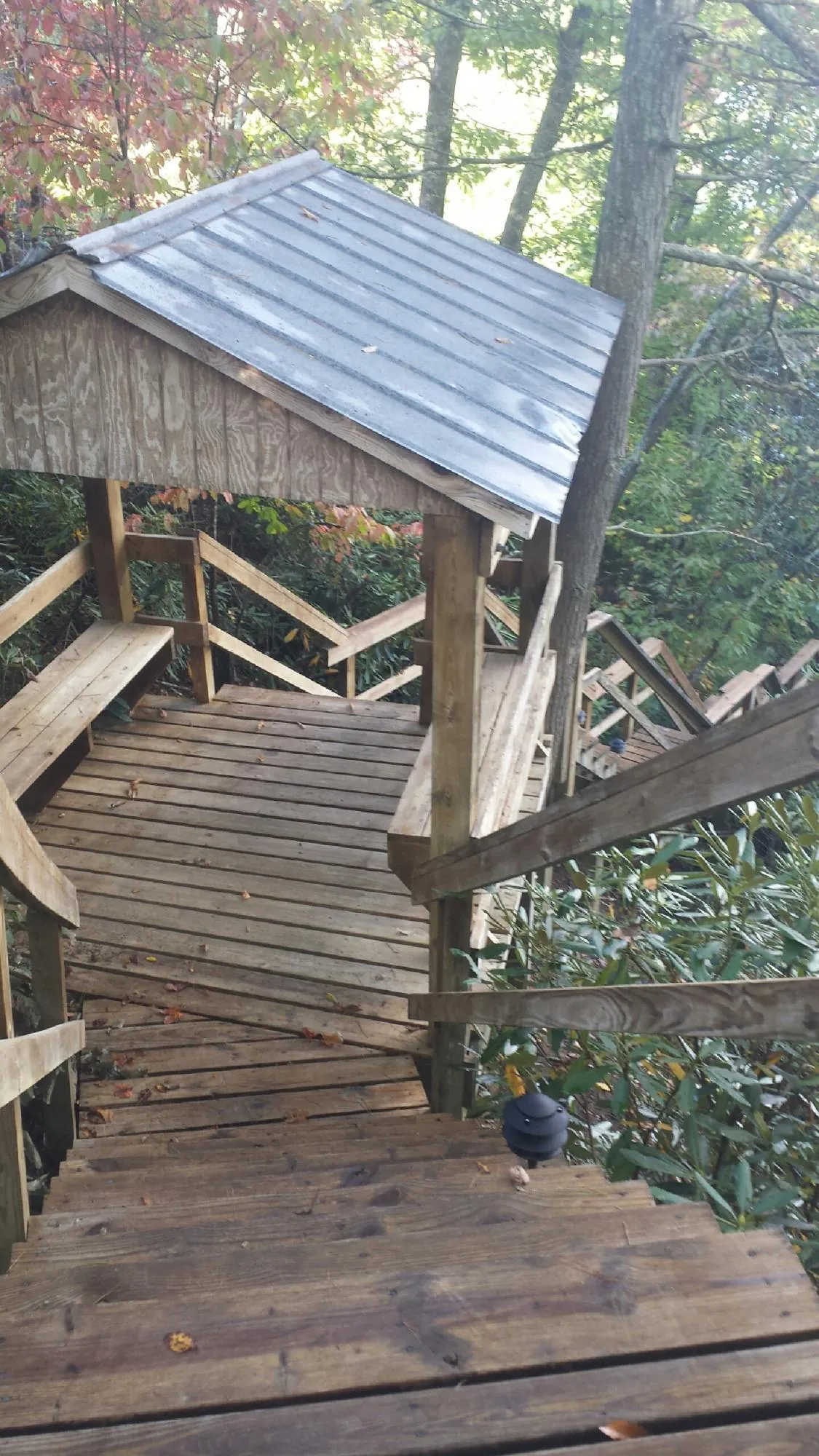 Metal roofed shelter over wooden steps on a wooded walkway — Skylight Repair & Installation work by our crew in York Springs