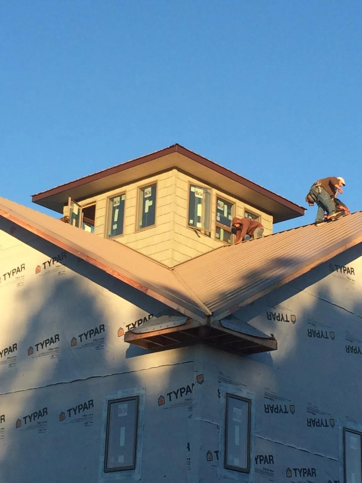 Roofers working around a rooftop cupola on a new metal roof at sunset — Roof Waterproofing in York Springs by Roofing Brothers